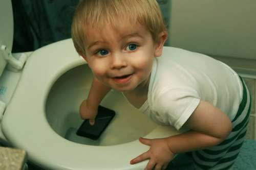 Copilul pune telefonul in toaleta